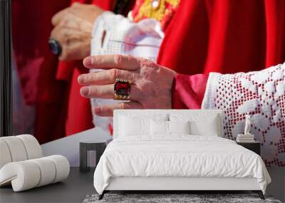 hand of the cardinal with a showy cassock ring with red ruby during the blessing of the faithful at the end of the mass Wall mural