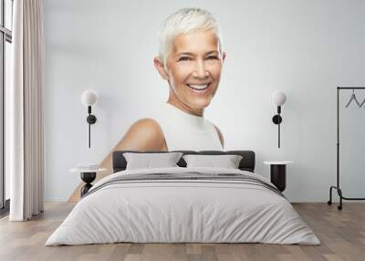 Beautiful smiling senior woman with short gray hair posing in front of gray background. Beauty photography. Wall mural