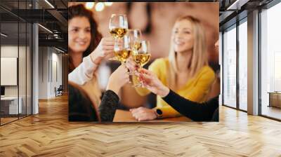 Girlfriends drinking wine and chatting while sitting in the bar. Wall mural