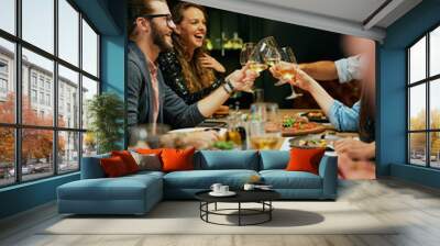 Group of best friends sitting in restaurant, making a toast and celebrating. Wall mural