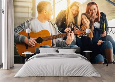 happy group of friends enjoying playing guitar and singing toge Wall mural