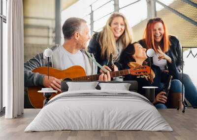 happy group of friends enjoying playing guitar and singing toge Wall mural