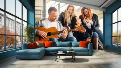 happy group of friends enjoying playing guitar and singing toge Wall mural