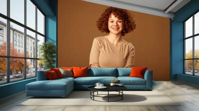 Portrait of a cute ginger girl with curly hair. Wall mural