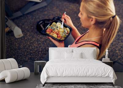 Top view of woman eating healthy food while sitting in a gym. Healthy lifestyle concept. Wall mural