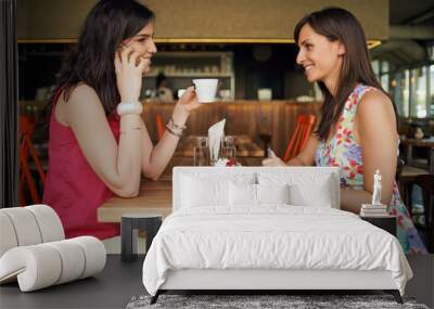 Two girls in a coffee shop on meeting, talking, discussing Wall mural