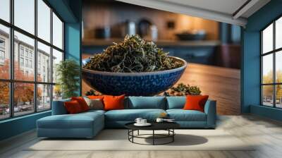 A close-up shot of a bowl filled with dried seaweed, sitting on a wooden table in a kitchen setting. The bowl is decorated with blue and white patterns, and the seaweed is a vibrant green. Wall mural