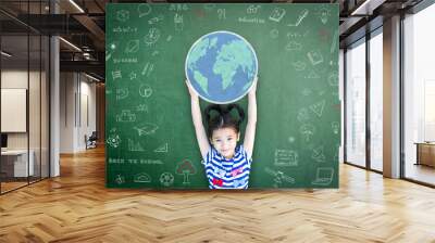 Educated school kid lifting world globe chalk doodle drawing on green chalkboard for education concept Wall mural