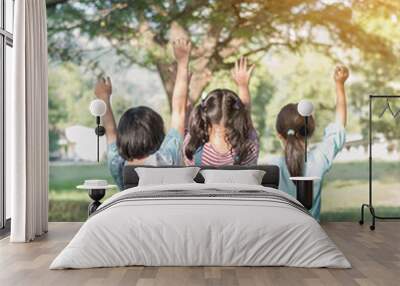 Happy kids in the park having fun sitting under tree shade playing together enjoying good memory and moment of girl student lifestyle with friends in school time day for children friendship concept Wall mural