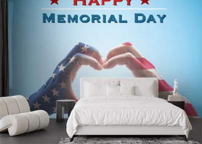 Happy memorial day with America flag pattern on people hands in heart shape isolated on blue sky background Wall mural