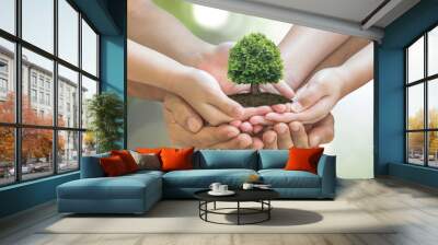 parent - children planting together big tree on family hands on blur nature greenery forest backgrou Wall mural