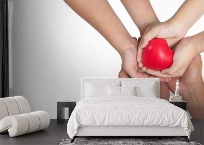 Parents and children’s hands (isolated on white background with clipping path) supporting red heart together for life insurance, organ donor donation and health assurance Wall mural