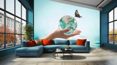 World ocean day,, saving water campaign, sustainable ecological ecosystems concept with green earth on woman's hands on blue sea background : Element of this image furnished by NASA . Wall mural