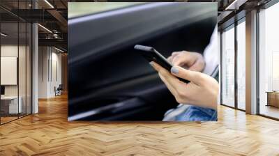 close up businesswoman hand holding smartphone to checking job and reading  mail inside car before go to meeting at company for business and transport concept Wall mural