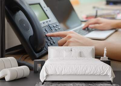 close up man hand pointing try to press button number on telephone office desk.multitasking employee concept Wall mural