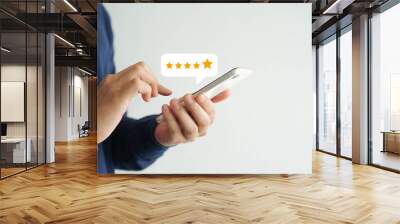 close up on customer man hand pressing on smartphone screen with gold five star rating feedback icon and press level three rank (good) for give score point to review the service business concept	 Wall mural