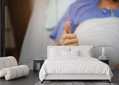 close up patient man hand show thumb up for good insurance or better medical , healthy life concept Wall mural