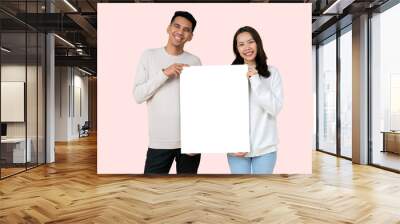 close up young lover asian people standing with happiness smiling and holding white mockup board together (for add content) isolated on pale pink color background for valentine day , family  lifestyle Wall mural