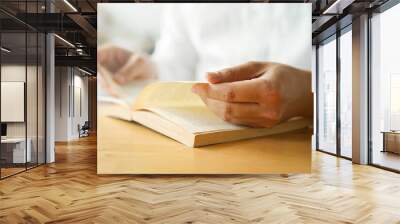 close up young man hand open bible book and reading sentence and worship in the church for hope an religion of christian concept Wall mural