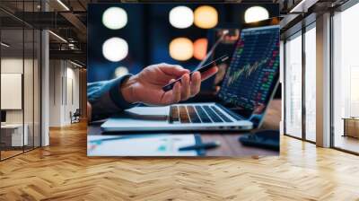 Close-up of a hand holding a mobile phone in front of a laptop. Work media, doing business, using technology for financial transactions or shopping, making various contracts. Wall mural