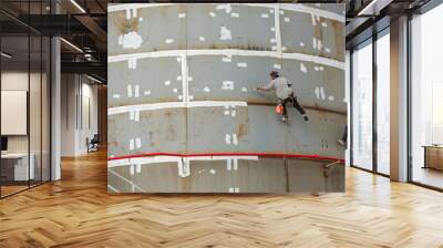 industrial rope access worker hanging from tank oil shell plate Wall mural