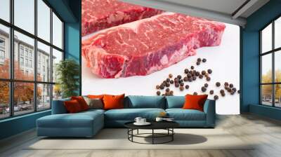 Raw Beef Strip Loins Steak and Some Black Pepper Corns on a White Quartz Kitchen Countertop Wall mural