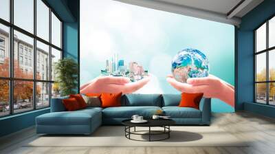 Earth Day concept:  Two human hand holding big city and earth globe on blue nature background. Elements of this image furnished by NASA Wall mural