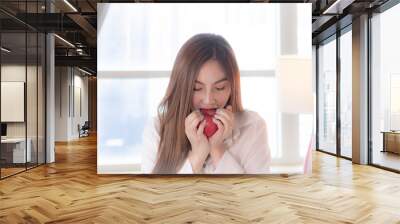 Healthy eating and diet concept: Portrait of Asian woman with red apple in the bed Wall mural