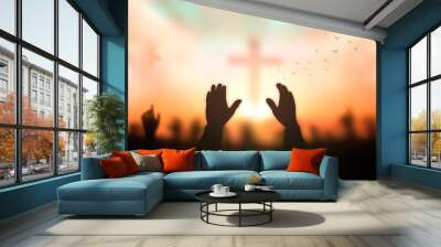 Resurrection of Easter Sunday concept: Silhouette christian people hand rising over blurred cross on spiritual light background Wall mural