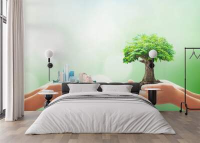 world environment day concept: two human hand holding big city and tree over blurred nature backgrou Wall mural