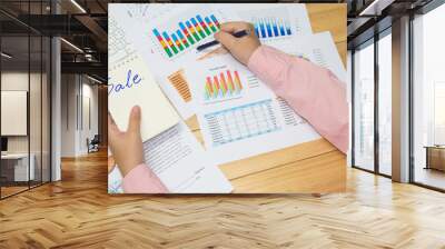 hand and arm business man point analysis financial paper charts and graphs on the wooden table background Wall mural