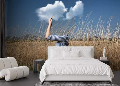 Surrealism with a woman holding a mirror and covering her face in the field with a transparent background behind the mirror Wall mural