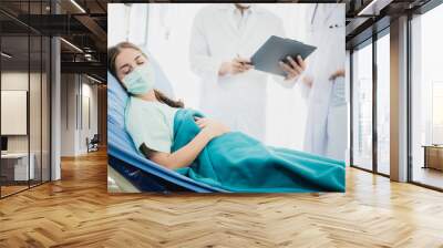 A young female patient is sleeping in a nursing room while recuperating in hospital Wall mural