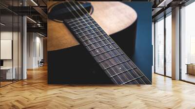 Acoustic guitar, music instrument resting against a dark black background with copy space, Close-up of wooden classic guitar Wall mural