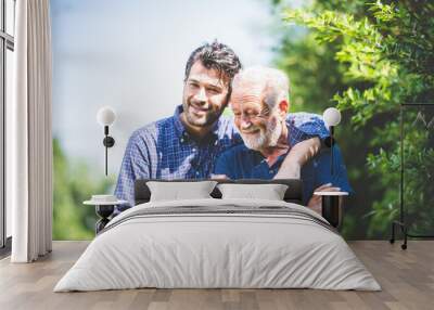 Adult hipster son and old senior father stay for work at home, two generations have a beard talking together and relaxing with smile, happy enjoy living to isolation quarantine at home, father's day Wall mural