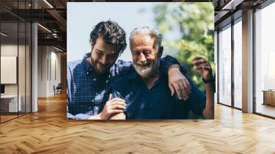 Adult hipster son and old senior father stay for work at home, two generations have a beard talking together and relaxing with smile, happy enjoy living to isolation quarantine at home, father's day Wall mural