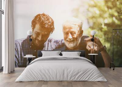 An adult hipster son and old senior father stay for work at home, two generations have a beard talking together and relaxing with smile, happy and enjoy living to isolation quarantine at home Wall mural