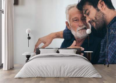 An adult hipster son and senior father at home, talking. Wall mural