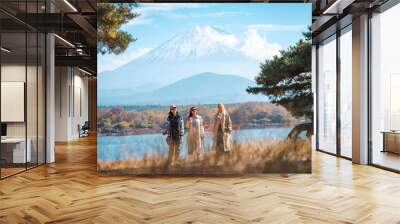 Attractive girl friends happy and fun together while travel Mt.Fuji landscape view and looking beautiful red maple tree leaf falling in autumn, Happy Asian woman travel in Japan on holiday vacation Wall mural