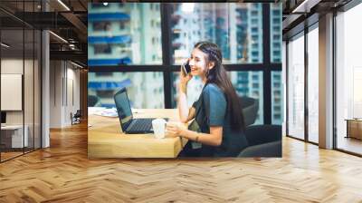 Beautiful business women workink with mobile phone and computer at the skyline office Wall mural