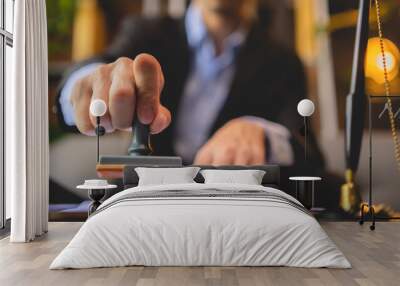 Close-up of a person's hand stamping with approved stamp on approval certificate document public paper at desk, notary or business people work from home, isolated for coronavirus COVID-19 protection Wall mural