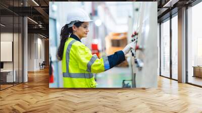 Female engineer using laptop computer for safety control checks or manufacturing maintenance work in factory building or construction site. woman engineer inspector working in industry product line Wall mural