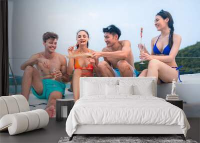 happy man in swimwear and woman in bikini having laugh fun in summer trip with friends group by eat bar-b-q grill and wine party drink, friendship vacation travel on sailboat yacht at the ocean sea Wall mural