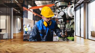 Production engineers are assisting adjusting and maintaining factory machine, Male workers technician examining control the industrial technology tool, professional repair men work in industry plant Wall mural