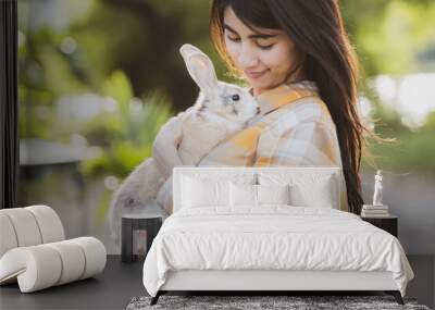 relationships of cheerful rabbit and happy young human girl, Asian woman holding and carrying cute rabbit with tenderness and love. Friendship with cute easter bunny. Happy of Easter's Day Wall mural