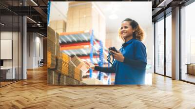 warehouse worker using bar code scanner to scanning box and analyze newly arrived goods for further placement in storage department, Working at warehouse. Wall mural