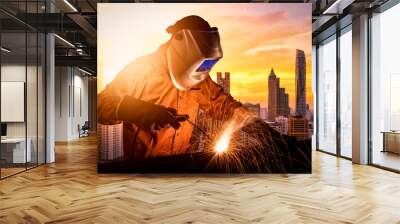 Industrial worker welding steel of construction structure for infrastructure architecture building project. Wall mural