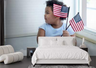 Curly hair little girl with American flag in her hand, on fourth of July Independence day, flag day concept Wall mural