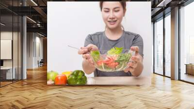 Enjoyed Asian woman eating vegetable salad. Wall mural