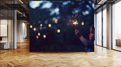 The photo shows a child holding a firework in his hand. The child is in the dark, and the firework is lit, creating a beautiful and magical scene. Wall mural